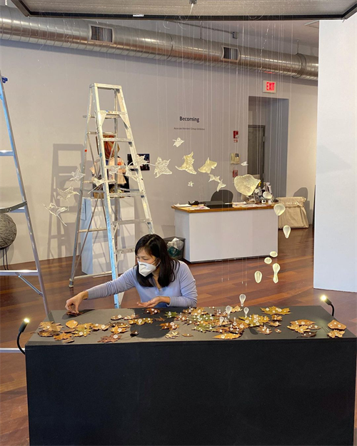 Yuko Oda monta la obra de arte en la Boston Sculptors Gallery.